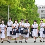 夏服のワンピースに身を包んで通学路を歩く生徒たち＝１６日朝、神戸市灘区王子町（撮影・秋山亮太）
