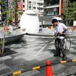 「さんきたアモーレ広場」の地面を洗浄する作業員＝神戸市中央区加納町４