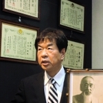 開業医として地域医療に取り組んだ祖父紀一さんの遺影を前にするナガタ薬品の中島康伸社長＝神戸市須磨区弥栄台１