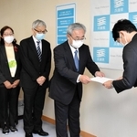 斎藤元彦知事（右）に要望書を手渡す「つなぐ会」代表理事の寺田真治さんら＝兵庫県庁