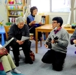 岩手県大槌町の仮設住宅を訪問し、沖縄の三線で交流する稲垣暁さん（右から２人目）＝２０１４年３月（提供写真）