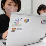 パソコンにアライのワッペンを貼るＰ＆Ｇジャパンの社員。デザインに「暗闇の向こうにある明かりになれれば」との思いが込められる＝Ｐ＆Ｇジャパン本社