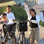 汗を拭うようなしぐさの女性＝２９日夕、神戸市中央区波止場町（撮影・吉田敦史）