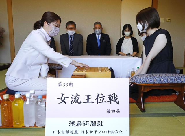 女流王位戦第４局で初手を指す里見香奈女流王位（左）。右は西山朋佳女流二冠＝７日午前、徳島市、ＪＲホテルクレメント徳島