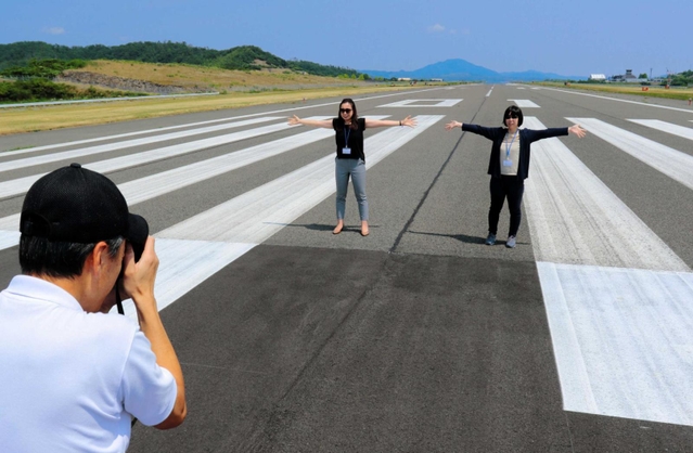 過去に開かれた但馬空港の見学ツアー。滑走路で記念撮影も＝豊岡市岩井
