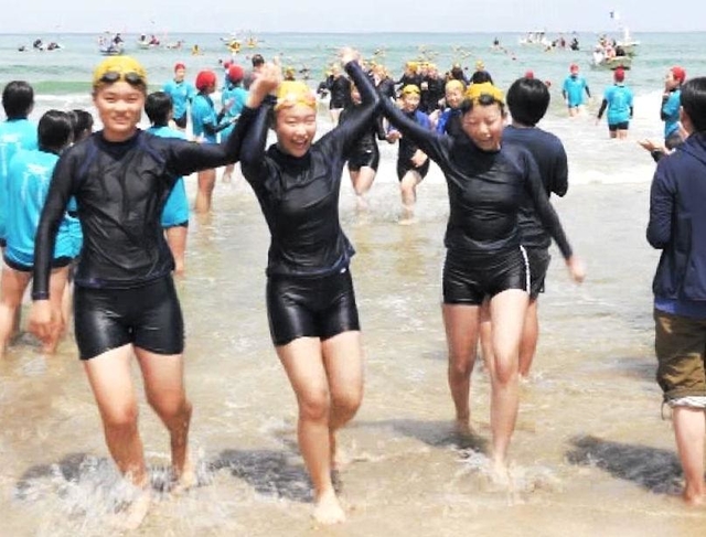 手をつないで完泳を喜ぶ女子生徒たち（ベイ・コミュニケーションズ提供）