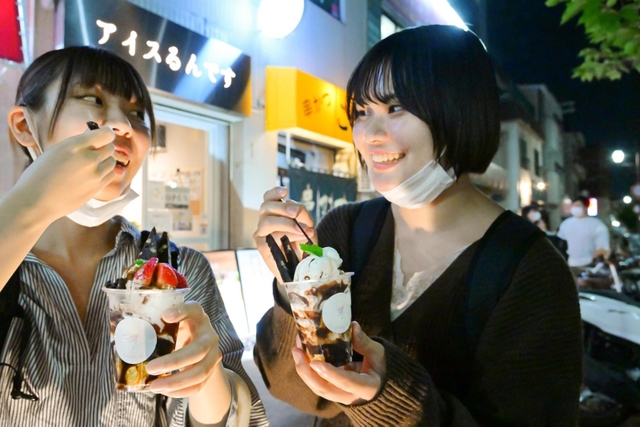 夜空の下、アイスをおいしそうに食べる大学生＝神戸市須磨区平田町１、「アイスるんです」（撮影・秋山亮太）