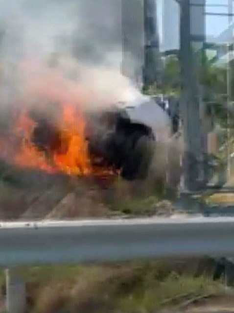 高速道路脇に突っ込み、炎上する乗用車＝５月５日午後１時半ごろ、淡路市尾崎（提供）