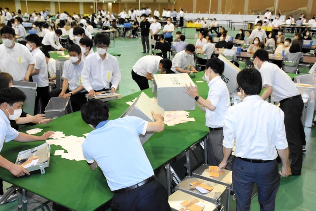 開票箱を開ける市職員＝１２日午後９時３１分、加古川市西神吉町鼎、加古川市立総合体育館