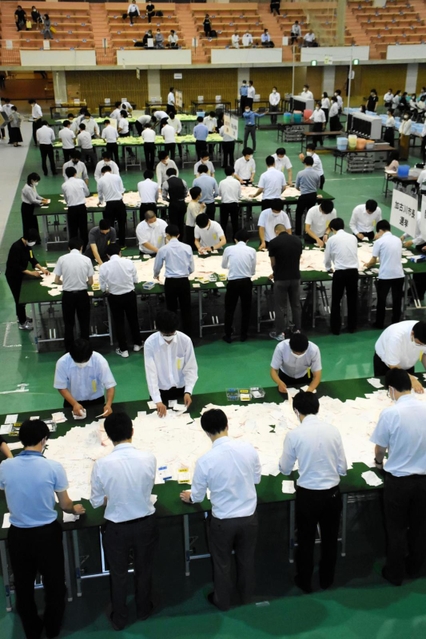 加古川市長選と市議選の開票作業を進める市職員＝１２日午後９時３９分、加古川市西神吉町鼎、加古川市立総合体育館