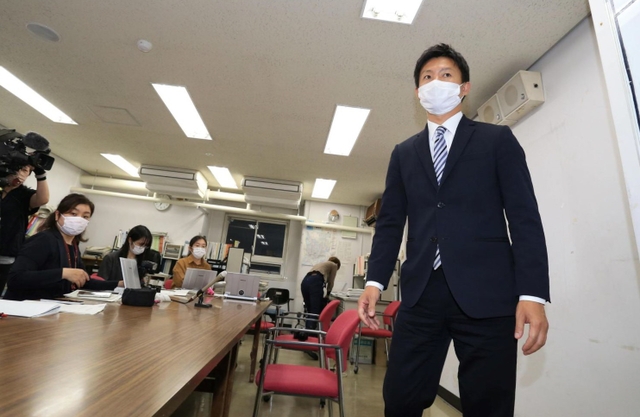 政務活動費にからむ納品書を偽造していた疑いがある光本圭佑・尼崎市議（右）＝１４日午後、尼崎市東七松町１、尼崎市役所