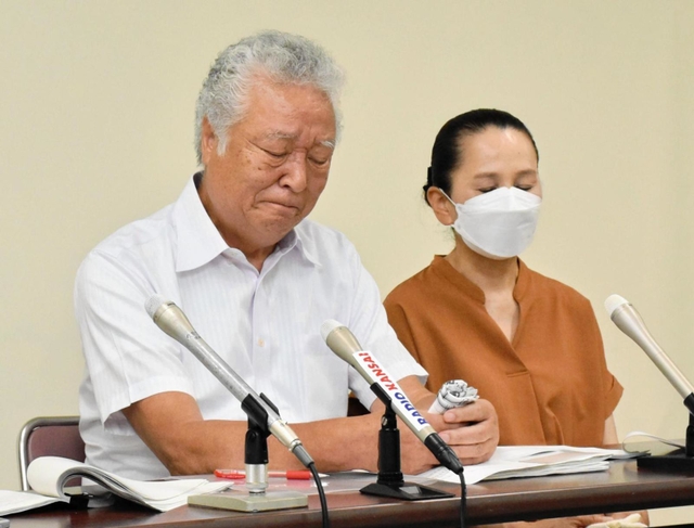 悔しさで唇をかむ木戸一仁さん（左）と妻久美子さん＝２２日午後、神戸市中央区橘通３、市立婦人会館