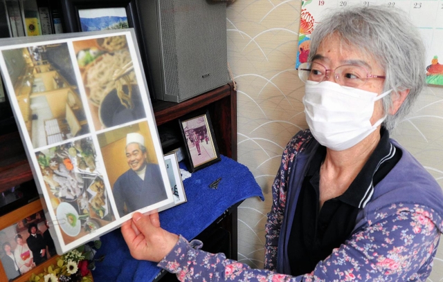 写真を手に夫の闘病生活を振り返る青野いずみさん＝明石市内
