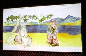 「絵本語り」より。山ノ上のおじ（左）、小太郎を抱いた犀龍