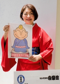 メリケンさんのイラストを手にする桂あやめさん＝神戸市兵庫区新開地２