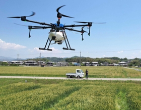 小麦畑の上を飛ぶ大型ドローン。農作業の効率化と脱炭素に貢献している＝加西市玉野町（ドローンで撮影・中西幸大）