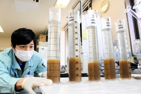 エアレーションタンクから採取した水で微生物の沈殿具合を調べる増田晴樹さん＝明石市大久保町八木、市立大久保浄化センター