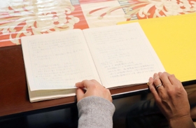 里親になった経緯や日々のやりとりを記したノートを親子で見返す＝神戸市北区（画像の一部を加工しています）