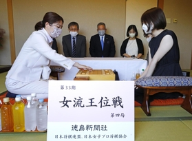 女流王位戦第４局で初手を指す里見香奈女流王位（左）。右は西山朋佳女流二冠＝７日午前、徳島市、ＪＲホテルクレメント徳島