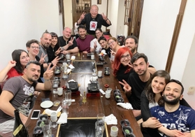 コロナ禍の前、来店客との記念撮影に応じる松平寿史さん（中央奥）。かつては外国人観光客が絶えなかった＝神戸市東灘区住吉宮町７（松平さん提供）