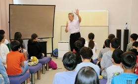 修学旅行で北淡震災記念公園を訪れた小学生を前に、被災体験を伝える米山正幸総支配人＝淡路市小倉