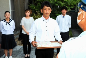 出火した車からけがをした４人を救助したとして、淡路広域消防事務組合の感謝状を受ける山田英輔さん（手前）と（後列左から）長女意寧さん、妻めぐみさん、長男臣之輔さん＝高砂市