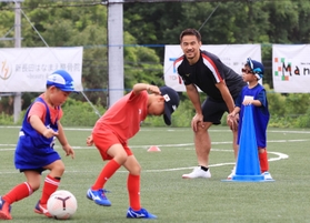環境配慮型グラウンドでサッカースクールの子どもたちと交流する岡崎慎司選手（右から２人目）＝１３日午後、神戸市西区平野町印路（撮影・吉田敦史）