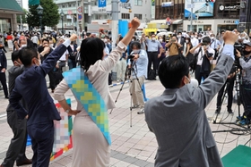 拳を突き上げ、支援者らと気勢を上げる候補者＝２２日午前、神戸市中央区（撮影・長嶺麻子、画像の一部を加工しています）