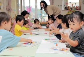 お絵描きを楽しむ１歳児たち。周辺で人口が増え、丹波篠山市立味間認定こども園は大勢の乳幼児で活気づく＝丹波篠山市西吹