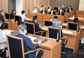 それぞれタブレットを開き、議事に臨む議員たち＝朝来市役所