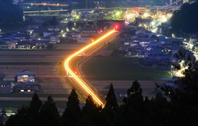 日没後、田園地帯を走る列車の光跡＝兵庫県神河町