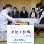 女流王位戦第４局で初手を指す里見香奈女流王位（左）。右は西山朋佳女流二冠＝７日午前、徳島市、ＪＲホテルクレメント徳島