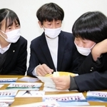 臨海学舎の写真を見ながら思い出話をする山瀬充子教諭（中央）と生徒たち＝西宮市学文殿町２、鳴尾高校