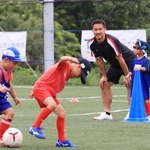 環境配慮型グラウンドでサッカースクールの子どもたちと交流する岡崎慎司選手（右から２人目）＝１３日午後、神戸市西区平野町印路（撮影・吉田敦史）