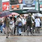 傘をさして横断歩道をわたる買い物客ら＝１４日午後、神戸市中央区元町高架通１