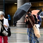 強い風雨の中を行き交う買い物客＝１４日午後、神戸市中央区元町通１（撮影・坂井萌香）