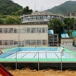 運動場いっぱいに設置されゆく仮設プール。３年ぶりの登場となる＝神戸市灘区箕岡通１、美野丘小学校（撮影・長嶺麻子）