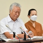 悔しさで唇をかむ木戸一仁さん（左）と妻久美子さん＝２２日午後、神戸市中央区橘通３、市立婦人会館