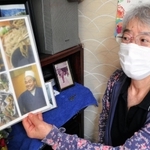 写真を手に夫の闘病生活を振り返る青野いずみさん＝明石市内