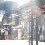 軒下にミストシャワーが設置された城下町の土産物店。ソフトクリームを食べて涼む観光客らも目立った＝２９日午後、豊岡市出石町