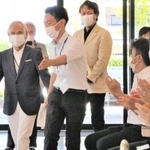 古野電気の社員に拍手で迎えられる堀江謙一さん（左から２人目）＝西宮市芦原町９、古野電気