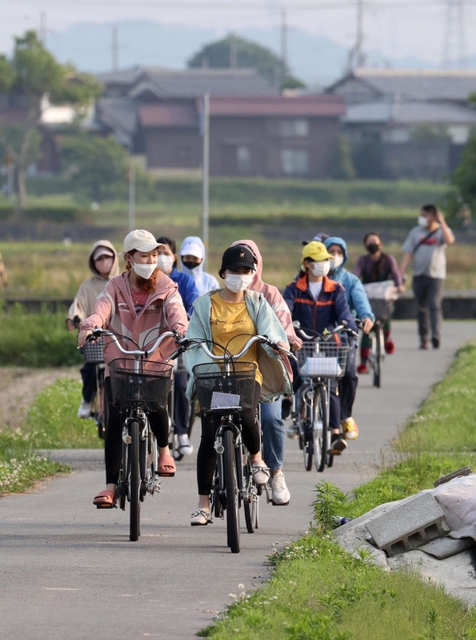 終業時刻とともに職場を後にする外国人労働者ら。車ばかりが通る街にひととき、自転車の車列が現れる＝加東市内