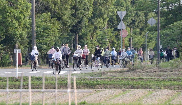 終業時刻とともに職場を後にする外国人労働者ら。車ばかりが通る街にひととき、自転車の車列が現れる＝加東市内