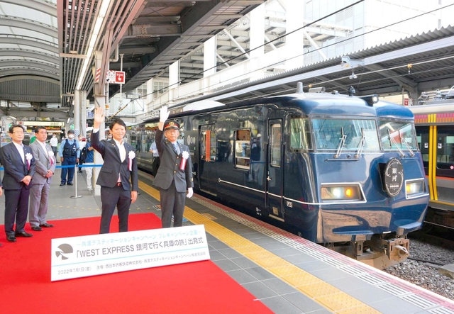 兵庫デスティネーションキャンペーンのプレ事業の一環で城崎温泉駅に向かうウエストエクスプレス銀河第１便の出発式。出発の合図で手を挙げる斎藤元彦兵庫県知事（右から２人目）＝１日午前、ＪＲ大阪駅