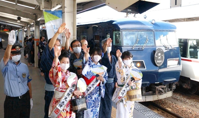 大阪から城崎にやって来た「ウエストエクスプレス銀河」と、笑顔の地元関係者＝１日午後、豊岡市城崎町（撮影・岡本好太郎）