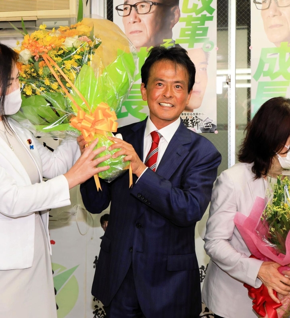 当選確実の報を受けて、花束を受け取る日本維新の会の片山大介氏（中央）＝１０日午後８時９分、神戸市中央区加納町４（撮影・鈴木雅之）