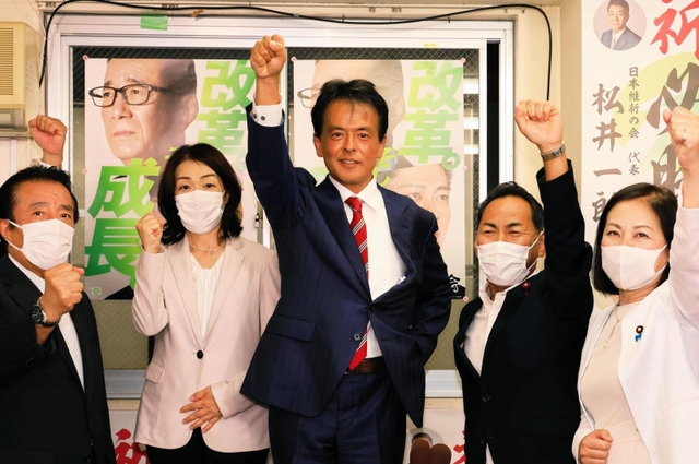 「ガンバロー」をする日本維新の会の片山大介氏＝１０日午後８時１９分、神戸市中央区加納町４