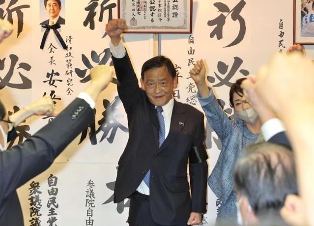 ４選確実の一報が届き、支持者と拳を突き上げる末松信介氏＝１０日午後８時２５分、神戸市中央区元町通１（撮影・小林良多）