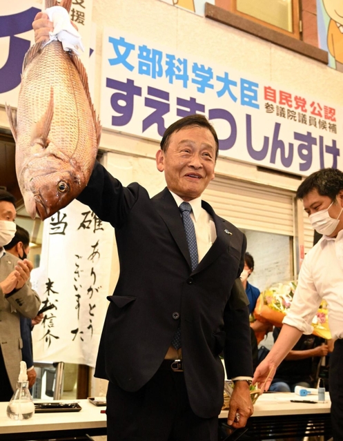当選が確実となりタイを掲げて喜ぶ末松信介氏＝１０日午後８時３６分、神戸市中央区元町通１（撮影・坂井萌香）