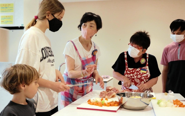 ウクライナからの避難民に、日本食の作り方を教える「プラス１（ＯＮＥ）ネット」のメンバー（右２人）＝神戸市長田区二葉町５